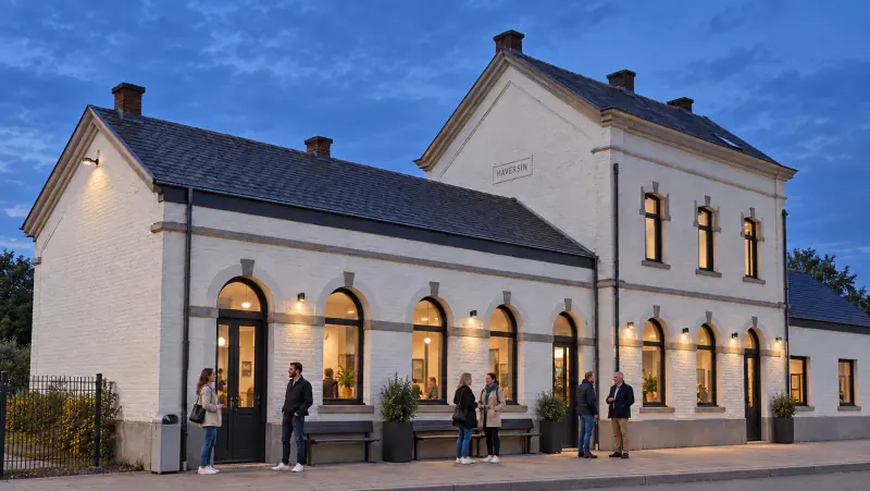 La gare d’Haversin au crépuscule, éclairée et animée par des invités.